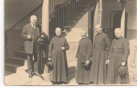 Prof. Clemens y varios sacerdotes cerca de una escalera